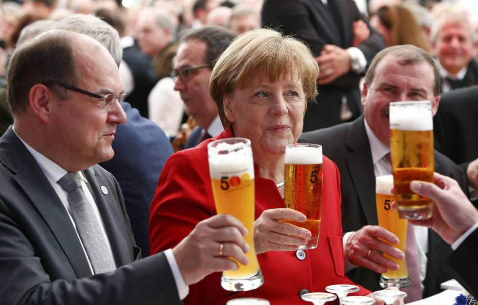 La canciller alemana,Angela Merkel, junto al ministro de Agricultura y Alimentación alemán, Christian Schmidt (izquierda), brinda durante una ceremonia de la Ley de la pureza de la cerveza en Ingolstadt, Alemania.