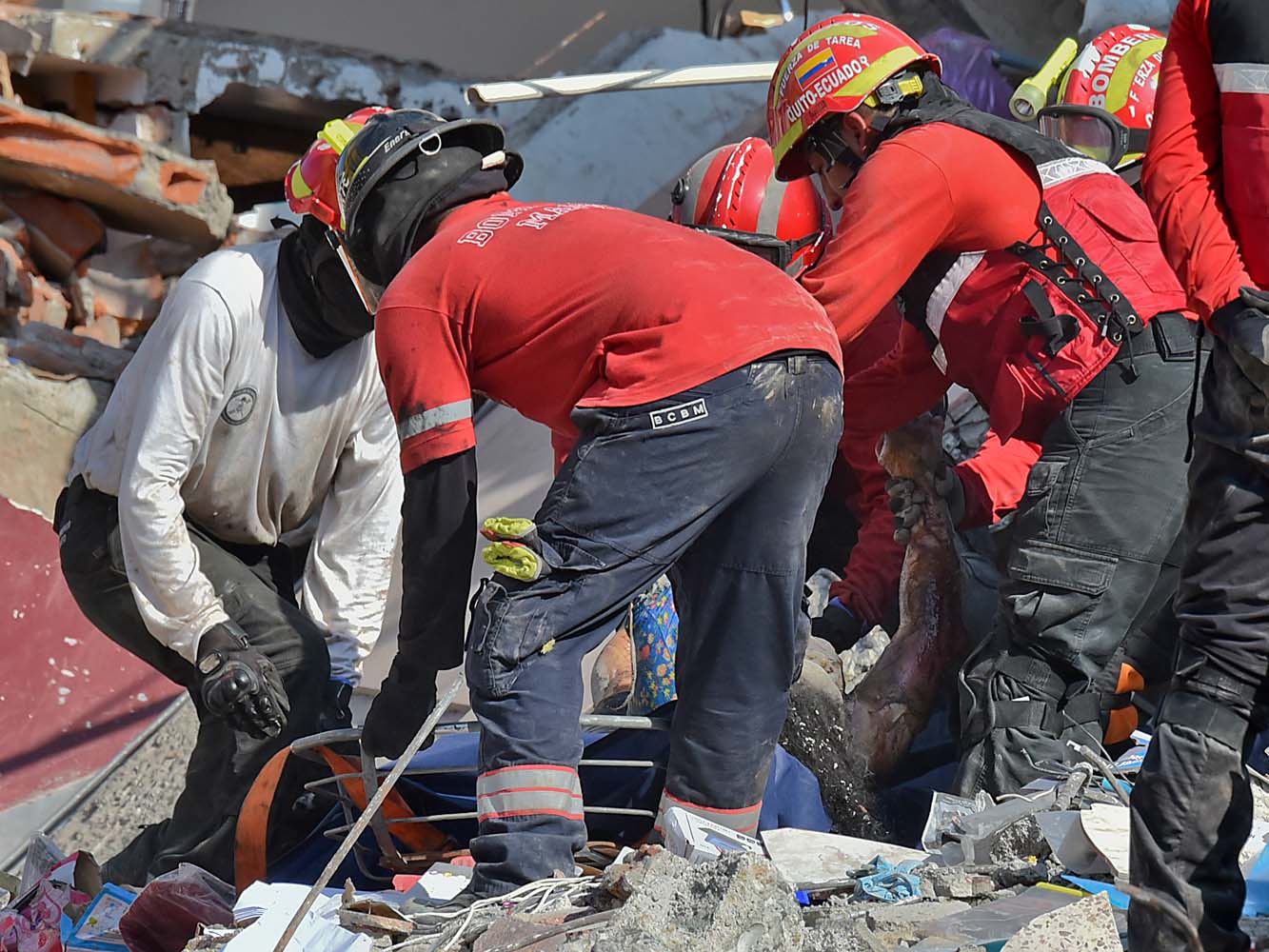 Rescuers remove a corpse from the rubble in Manta, Ecuador on April 19, 2016, two days after the 7.8-magnitude quake that struck the region. Rescuers and desperate families clawed through the rubble Monday to pull out survivors of an earthquake that killed at least 413 people and destroyed towns in a tourist region of Ecuador. / AFP PHOTO / LUIS ACOSTA
