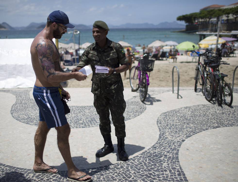 Un soldado reparte folletos informativos sobre el virus del Zika en la playa de Copacabana. Un soldado reparte folletos informativos sobre el virus del Zika en la playa de Copacabana.