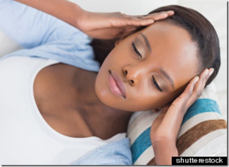 Black woman lying while having hands on temples in a living room; Shutterstock ID 114592780; PO: The Huffington Post; Job: The Huffington Post; Client: The Huffington Post; Other: The Huffington Post