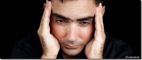 Classic portrait of an hispanic man suffering a strong headache or depression pressing his forehead with his hands isolated on black; Shutterstock ID 106997273; PO: The Huffington Post; Job: The Huffington Post; Client: The Huffington Post; Other: The Huffington Post