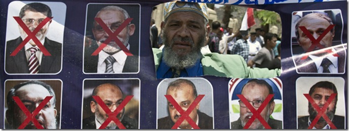 An Egyptian man holds a sign with portraits of Islamist leaders 