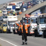 A rescue worker gestures in front of recovery trucks lined up to collect over 100 vehicles involved in multiple collisions, which took place in dense fog during the morning rush hour, on the Sheppey Bridge in Kent, east of London