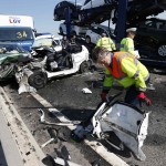 A rescue worker works amongst the wreckage of some of the 100 vehicles involved in multiple collisions, which took place in dense fog during the morning rush hour, on the Sheppey Bridge in Kent, east of London
