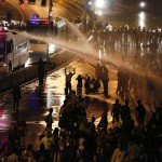 Riot police use water to disperse opposition demonstrators as they block the city's main highway in Caracas