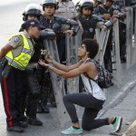 An opposition demonstrator gives flowers to a police officer in Caracas
