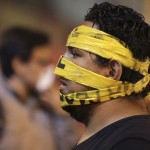An opposition demonstrator has his face taped during a protest against Nicolas Maduro's government in Caracas