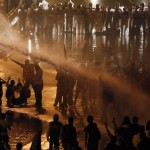 Riot police use water to disperse opposition demonstrators as they block the city's main highway in Caracas