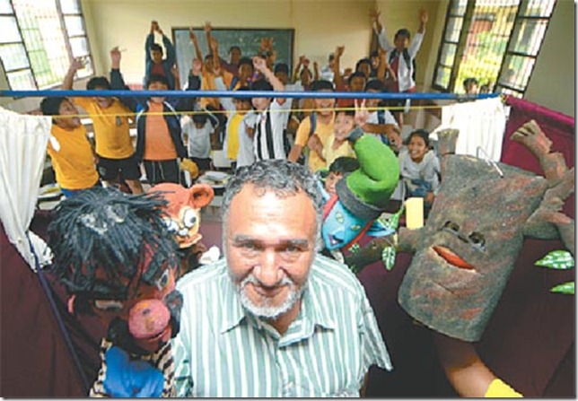 Zenón Quiroz con sus títeres. Al fondo los niños de la escuela Max Fernández, a quienes visitó miércoles