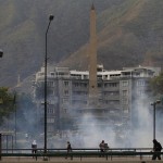 Anti-government protesters stand amidst teargas during a protest at Altamira square in Caracas