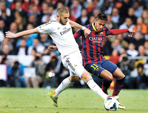 Enfrentamiento. Benzemá (blanco) domina el balón ante la marca de Neymar en un cotejo de Liga.