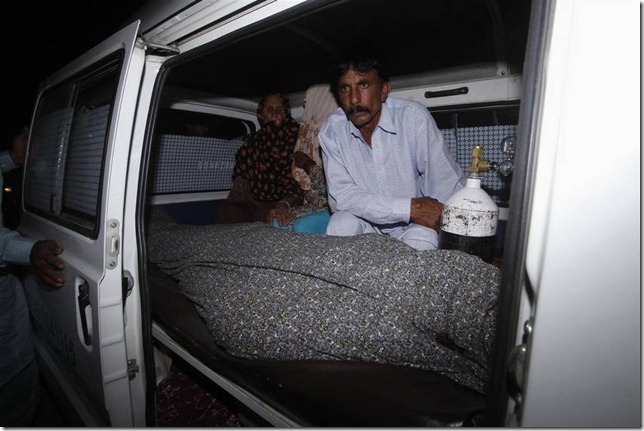 Mohammad Iqbal, esposa de la mujer lapidada, junto al cuerpo de su esposa, en Lahore.