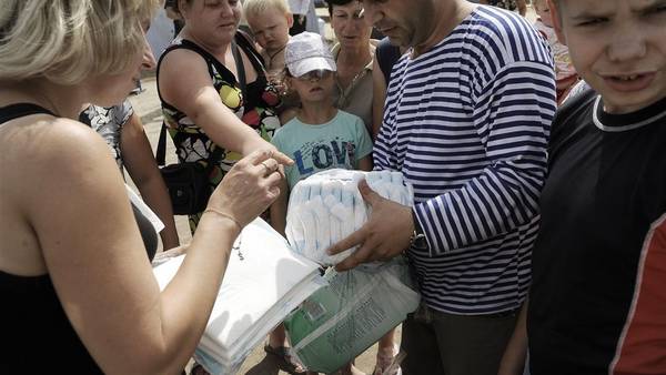 Un hombre distribuye ayuda humanitaria en un campo de refugiados en el este de Ucrania. AFP