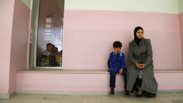 Niño con su madre en una escuela de Damasco