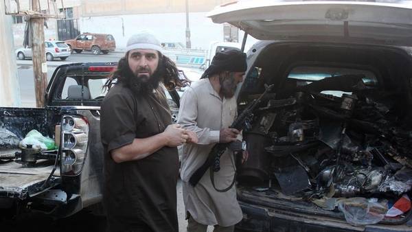 Combatientes del Isis cargan en un vehículo lo que dicen son los restos de un drone norteamericano estrellado en Raqqa. (AFP)