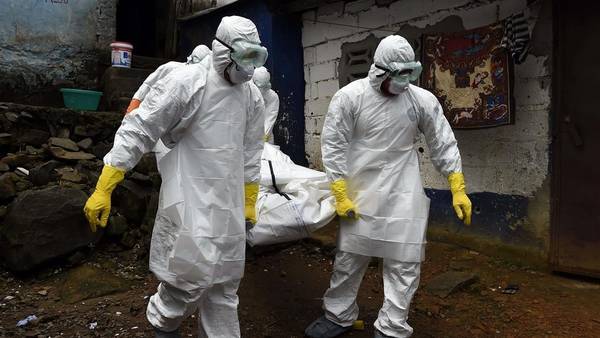 Personal médico de la Cruz Roja traslada el cuerpo de una víctima de ébola, retirado de una casa en Monrovia./AFP