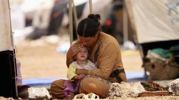 Una refugiada de la minoría Yazidi consuela a su hija en una carpa en el campo de Nowruz en Siria, tras huir de Irak. (Reuter)