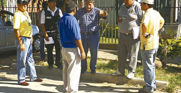 El fiscal José Parra, junto a investigadores policiales, revisa el lugar donde Santander murió abaleado