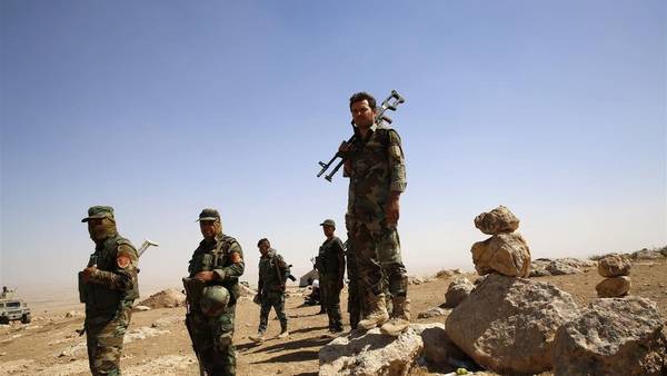 Combatientes kurdos, Peshmergas, cargan sus armas en la aldea iraquí de Baretle, controlada por los yihadistas del ISIS. (Reuters)