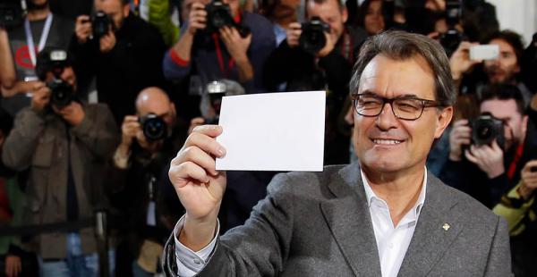 Artur Mas, principal impulsor de la independencia de Cataluña, sostiene su boleta antes de emitir su voto simbólico por la independencia catalana