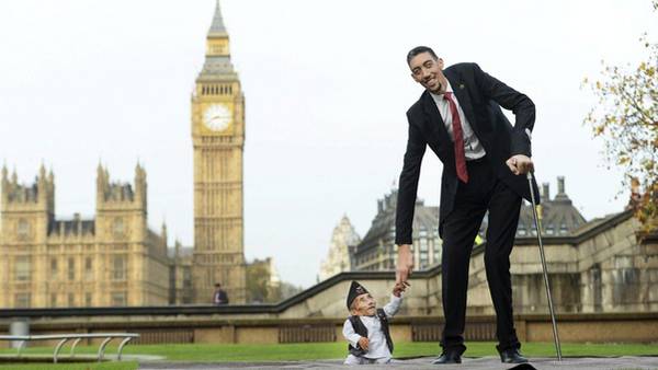 El nepalí Chandra Bahadur Dangi, el hombre más bajo del mundo, y el turco Sultan Kosen, el más alto, posan juntos con motivo del Día Mundial del Record Guinness. (AFP)
