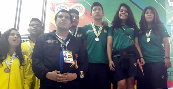 LOS MEJORES.  Los deportistas bolivianos en el podio junto con el entrenador Eduardo Peralta (de negro)