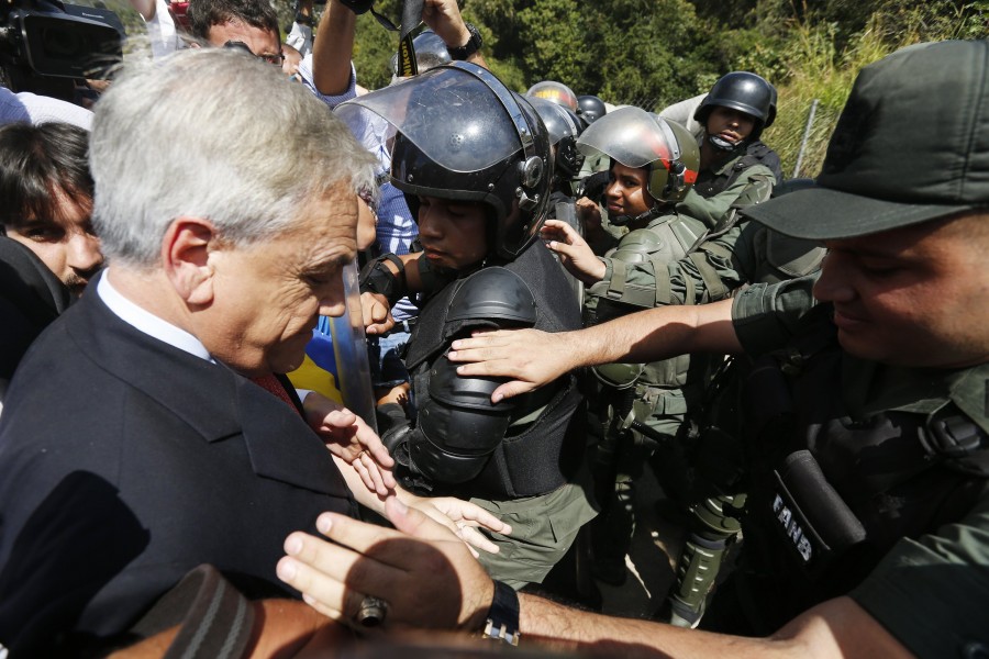 Former Chile's president Pinera walks among national guards outside the military prison of Ramo Verde at the outskirts of Caracas