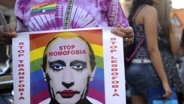 Un manifestante sostiene un cartel que representa el presidente ruso, Vladimir Putin, con maquillaje como protesta contra la homofobia y la represión en contra de los gays en Rusia. (AFP)