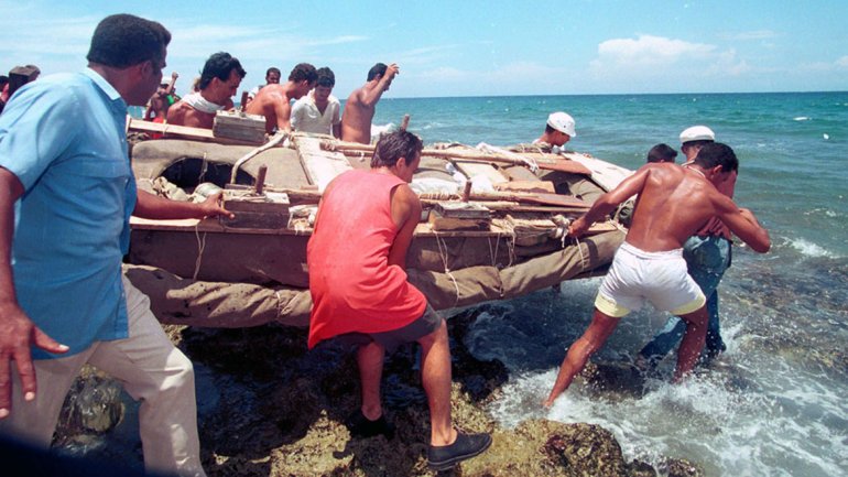 Varios cubanos no identificados bajan una balsa al mar, preparándose para salir de la costa cubana en Cojimar,  cerca de La Habana