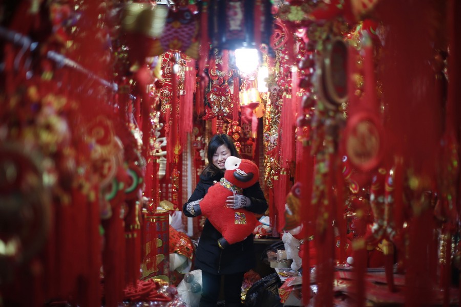 A woman looks at a toy sheep at a shop in downtown Shanghai