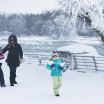 A family walks through the snow near the frozen Niagara Falls in Niagara Falls, New York