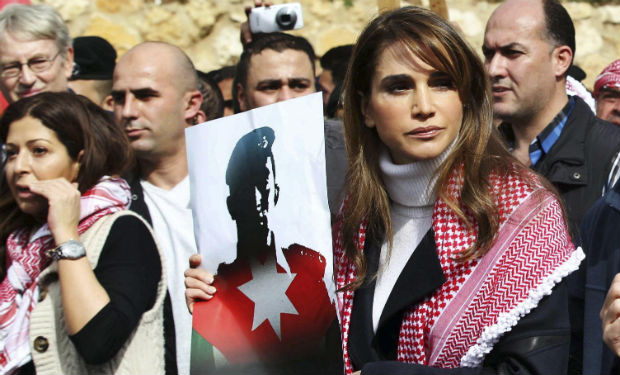 Reina de Jordania muestra una foto de piloto asesinado por EI en marcha que convocó a miles de personas. 