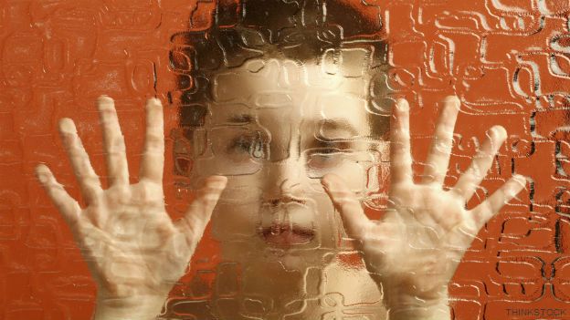 Un niño detrás de una pantalla de cristal
