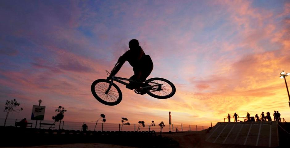Un ciclista realiza acrobacias durante la puesta de sol