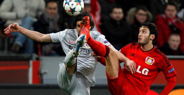 Hakan Calhanoglu, del Bayer Leverkusen disputa el balón con Tiago Mendes del Atlético de Madrid. El jugador del Madrid terminó expulsado por doble cartulina amarilla