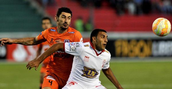 Ramón Abila de Huracán disputa el balón con Jorge Gonzales de Universitario. Los bolivianos n o pueden embocarla en el arco rival.