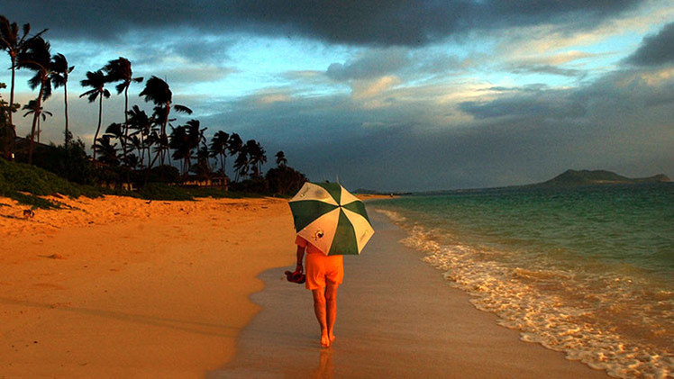 Una mujer camina por la playa. Hawai