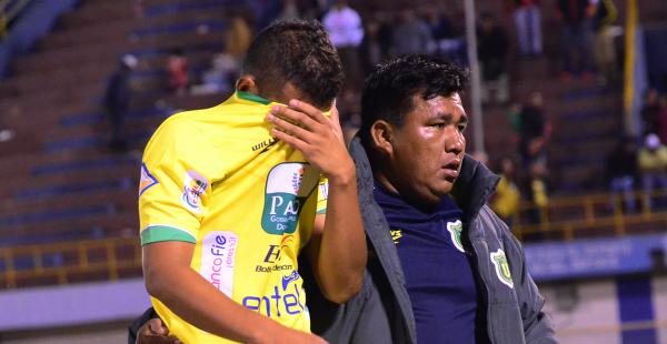 Juan Pablo Aponte fue uno de los que más sufrió por el descenso de Universitario de Pando esta noche en Cochabamba. En la imagen es acompañado por un miembro del cuerpo técnico