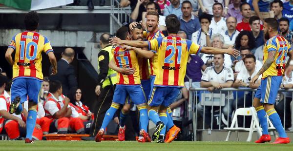 Rodrigo de Pablo, Paco Alcácer y Javi Fuego, de Valiencia, celebran el primer gol del compromiso ante el Real Madrid por la Liga española