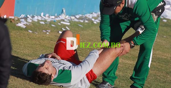 Raldes en el suelo es asistido por el kinesiólogo de la selección boliviana, Rudy Romero, en el estadio de Independiente de Rivadavia