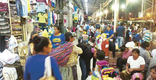 Aún no salió el sol y en los pasillos de la feria el trajín es intenso