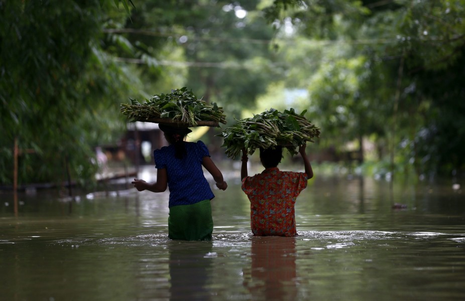 BIR02 DAR KA (BIRMANIA) 12/08/2015.- Dos mujeres caminan por las calles inundadas de Dar Ka (Birmania) hoy 12 de agosto de 2015. Casi un millón de personas se han visto damnificadas por las inundaciones que afectan gran parte de Birmania (Myanmar), provocadas por las intensas lluvias monzónicas que caen desde el mes pasado. El ministerio de Bienestar Social también indicó que el balance de víctimas ya superó el centenar, la mayoría de ellas en el estado Rakhine, en el oeste del país, según el diario Global New Light of Myanmar. EFE/Lynn Bo Bo
