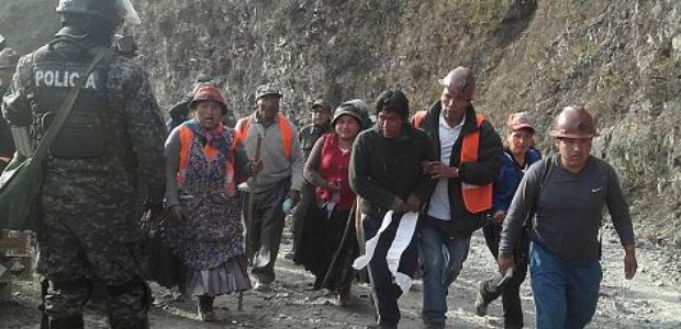 Un grupo  de cooperativistas traslada a uno de los heridos, en Tacacoma.