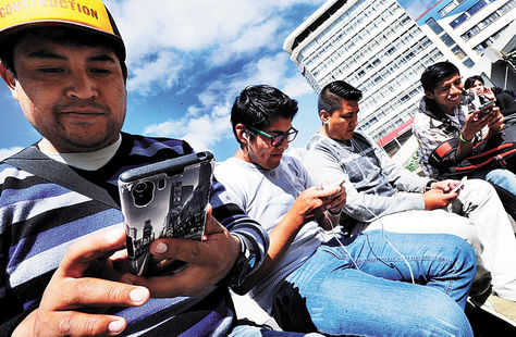 La Paz. Jóvenes hacen uso de sus smartphones (teléfonos inteligentes) en la plaza Camacho.