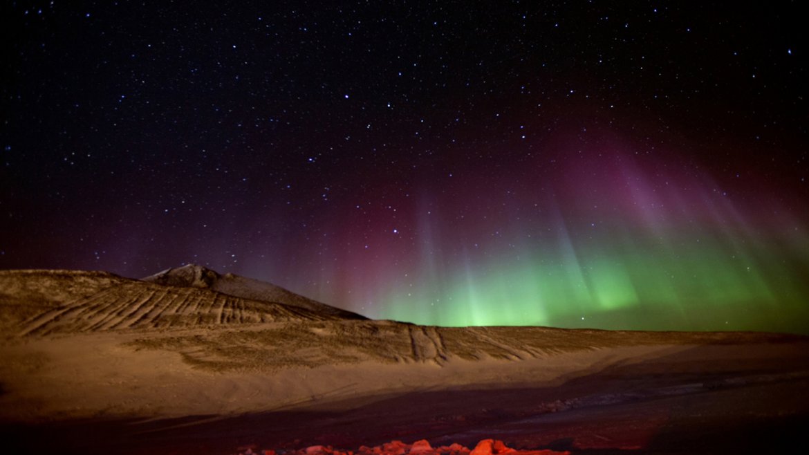 Una aurora con colores del arco iris ilumina el cielo de la noche cerca de la Estación McMurdo el 15 de julio de 2012.