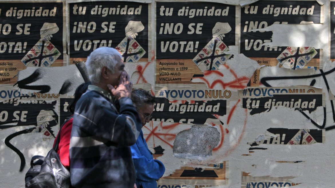 Unas personas caminan frente a afiches de campaña en un centro de votación previo a las elecciones generales que se realizarán este domingo en Guatemala Unas personas caminan frente a afiches de campaña en un centro de votación previo a las elecciones generales que se realizarán este domingo en Guatemala