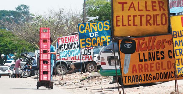 Un trabajador se ve obligado a usar la calzada ante la gran cantidad de letreros que copan la acera