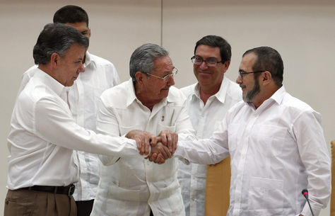 El presidente de Colombia Juan Manuel Santos (i), el presidente de Cuba Raúl Castro (c) y el máximo líder de las FARC, Rodrigo Londoño (d), alias "Timochenko", se dan la mano, durante un acto en La Habana (Cuba). 