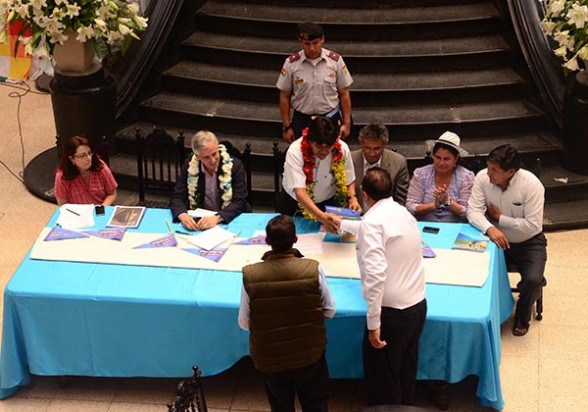 El representante de JOCA Bolivia y el Ministro de Obras Públicas saludan al presidente Evo Morales, el 12 de septiembre, en la firma del contrato. - Daniel  James Los Tiempos