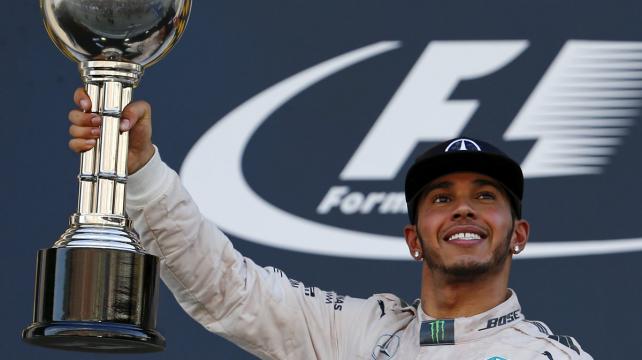 Hamilton muestra orgulloso su trofeo ganado la madrugada de este domingo en Japón. Foto. Reuters